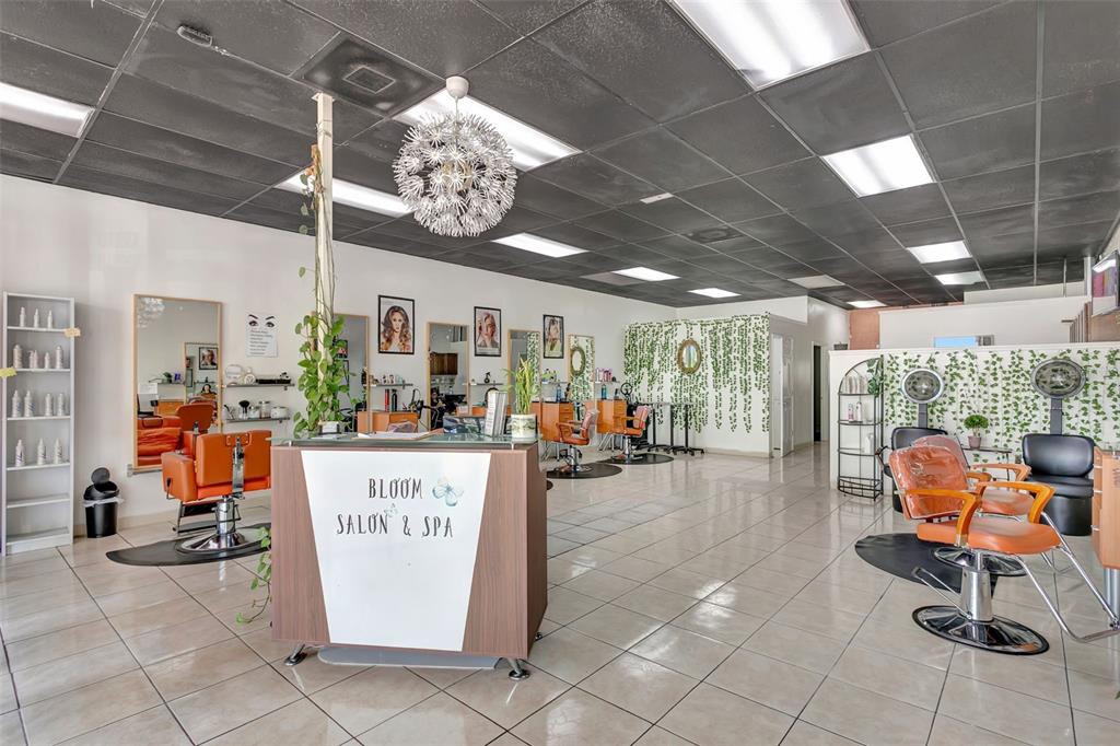 A hair salon features orange styling chairs, a reception desk, and a dark drop ceiling — 1903 E FL 60 UNIT D, VALRICO, FL