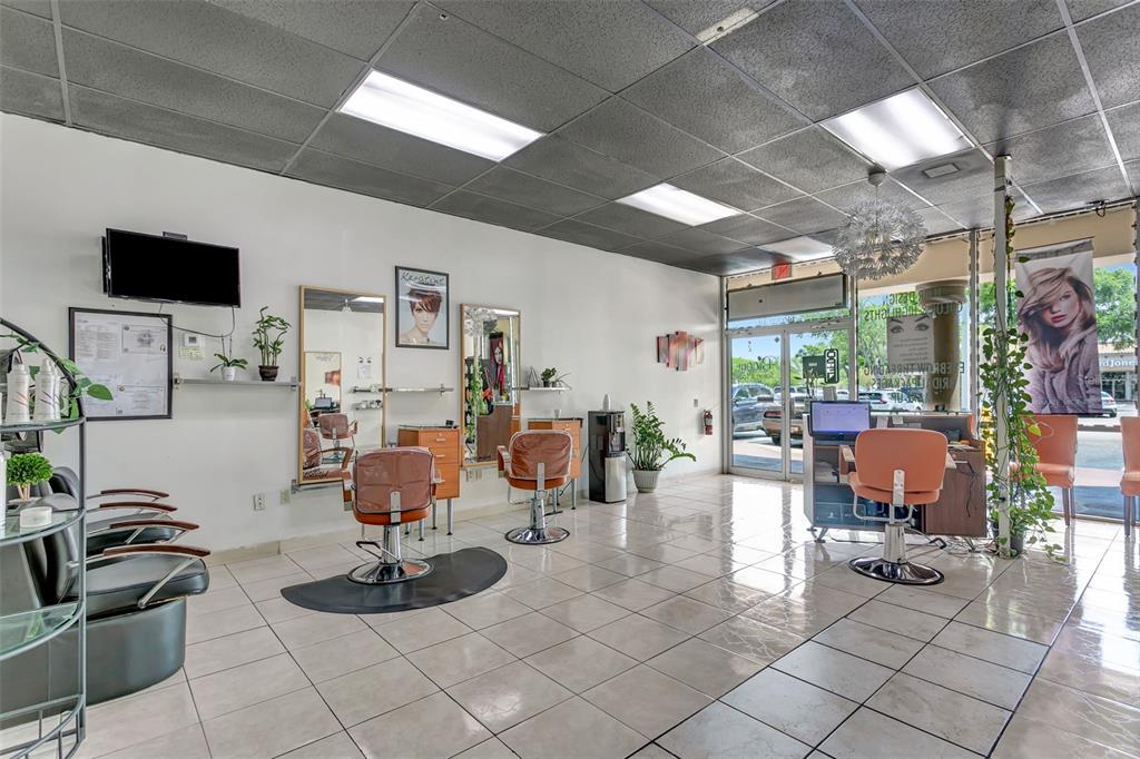 A hair salon interior features tiled floors, multiple styling chairs, mirrors, and large glass windows — 1903 E FL 60 UNIT D, VALRICO, FL