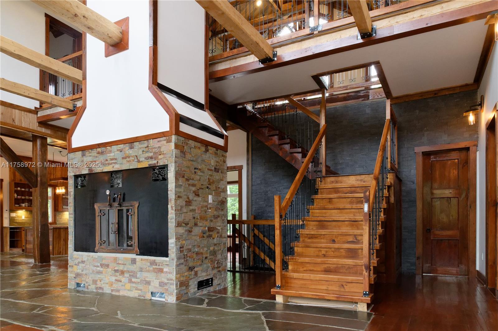 A rustic interior features a stone fireplace, wooden staircase, and exposed timber beams — 1150,10e Rang, QC J0K 1Z0, QC
