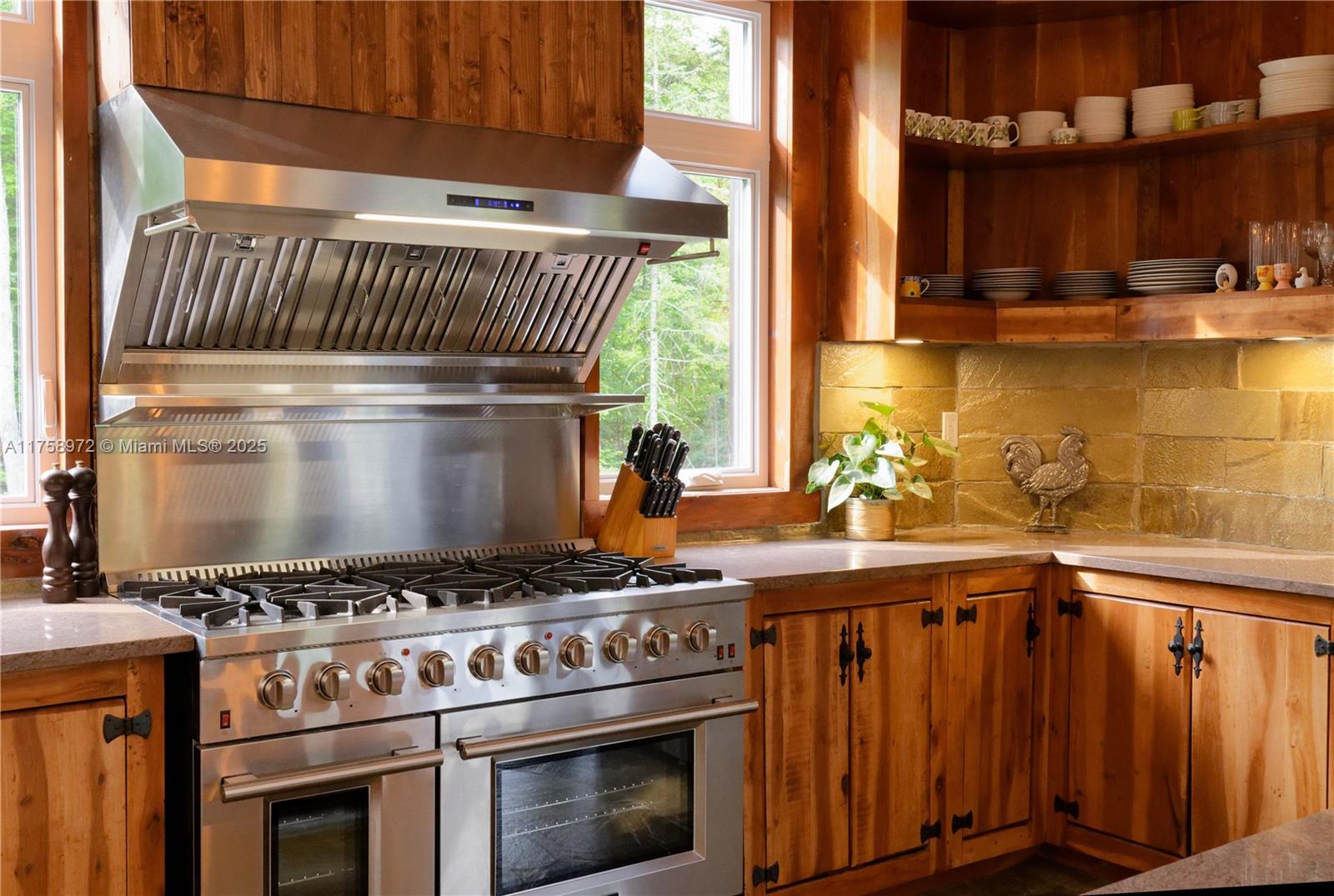 A rustic kitchen features wood cabinetry, a large stainless steel range, and open shelving — 1150,10e Rang, QC J0K 1Z0, QC