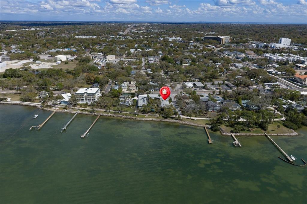 An aerial view shows a waterfront property with a red location pin and private docks — 1101 VICTORIA DRIVE UNIT 7, DUNEDIN, FL