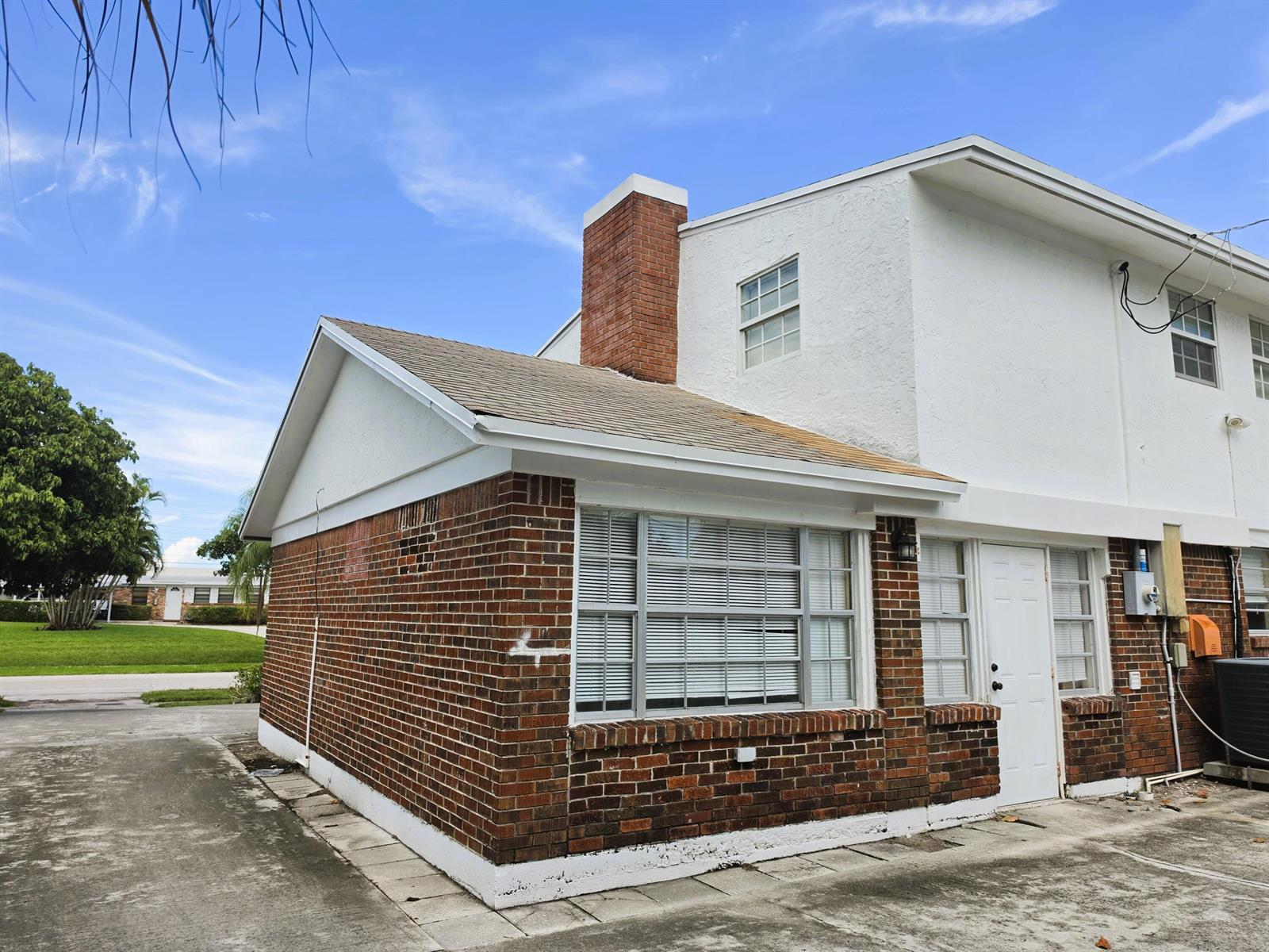 A two-story building with a brick lower level, white stucco upper level, and brick chimney — 814 Poplar Drive # B, Lake Park FL 33403, LAKE PARK, FL
