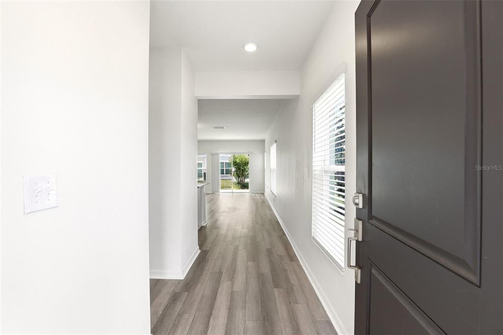 A view from an open front door into a hallway with wood-look flooring — 2274 CARRABELLE WAY, SANFORD, FL
