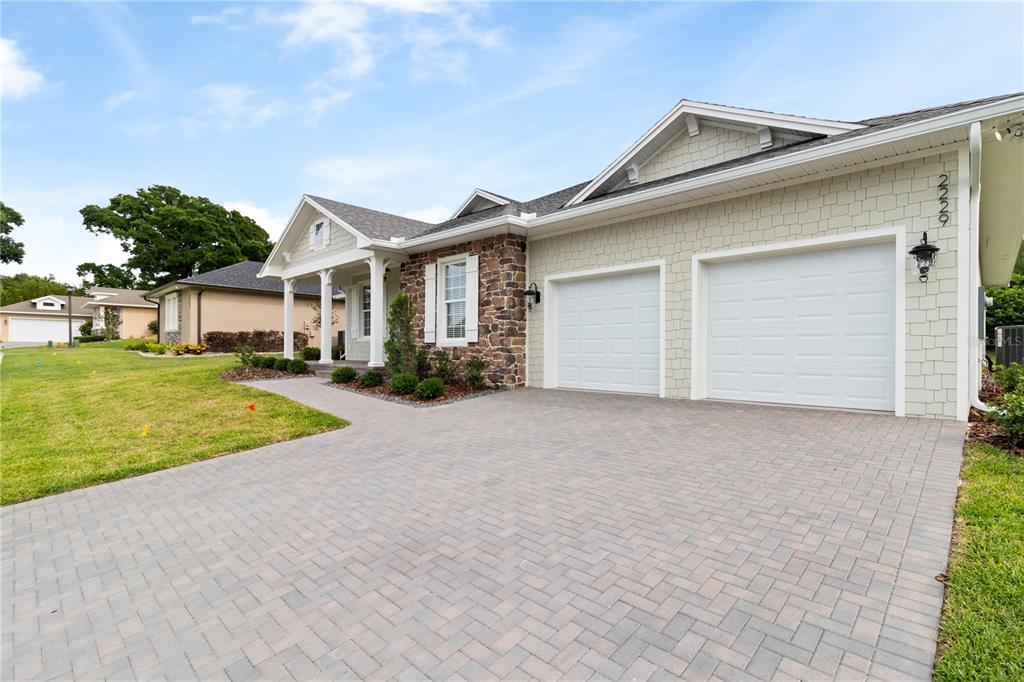 A single-story house features a stone facade, light-colored siding, a two-car garage, and a driveway — 2229 COACHMAN LOOP, LAKELAND, FL