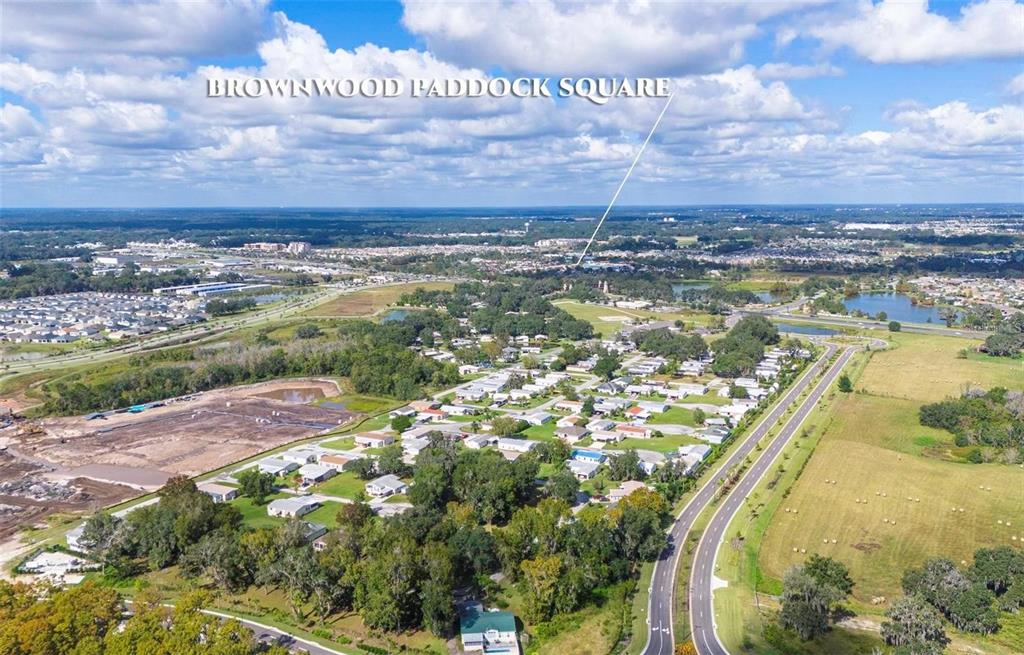 An aerial view shows a residential neighborhood, a road, and a distant commercial area — LOT 9 BLK D LEXINGTON CIRCLE, WILDWOOD, FL