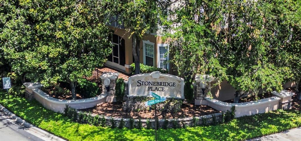 An exterior view of a Stonebridge Place community entrance sign surrounded by trees and landscaping — 3190 DANTE DRIVE UNIT 109, ORLANDO, FL