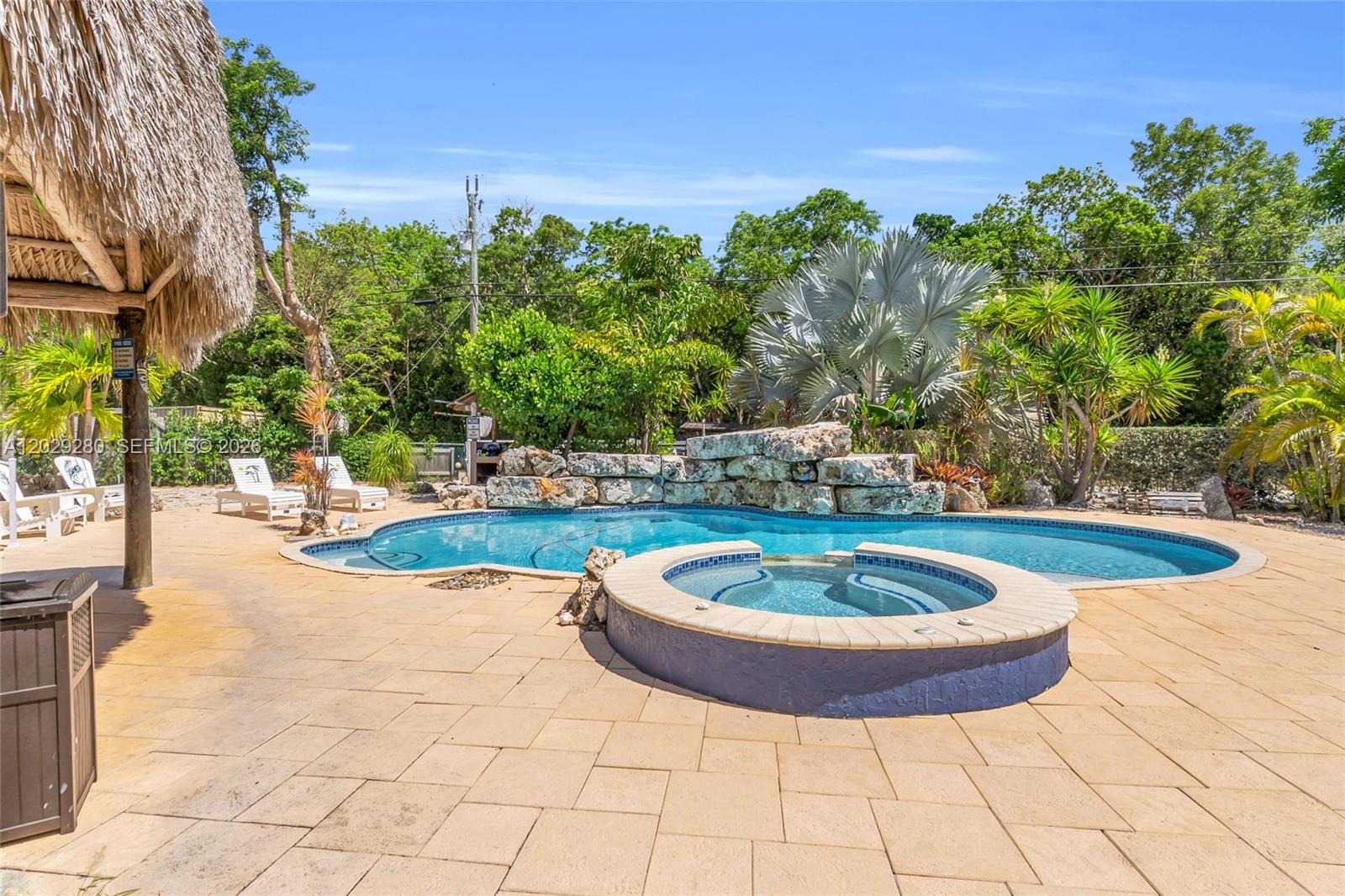 A backyard features a swimming pool, a raised hot tub, and a thatched-roof structure — 443 4TH Rd, Key Largo FL 33037, KEY LARGO, FL