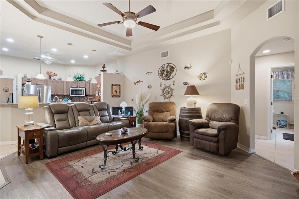 A living room features a leather sofa, two recliners, a coffee table, and nautical wall decor — 4 MILBARK DRIVE, HOMOSASSA, FL