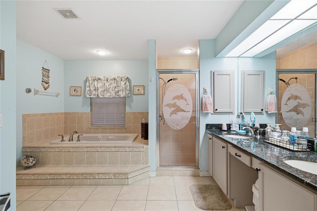 A bathroom features a tiled soaking tub, a glass-enclosed shower, and a double vanity — 4 MILBARK DRIVE, HOMOSASSA, FL