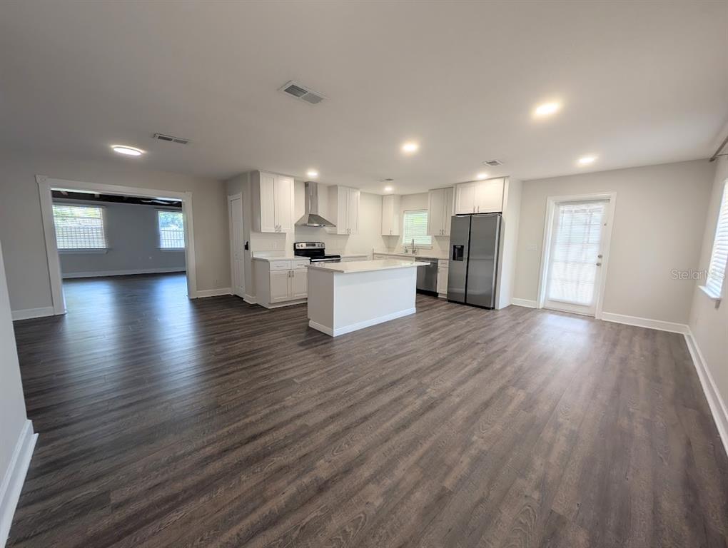 A single-story house with a light-colored exterior, a large tree, and a screened-in porch — 3902 W PAXTON AVENUE, TAMPA, FL