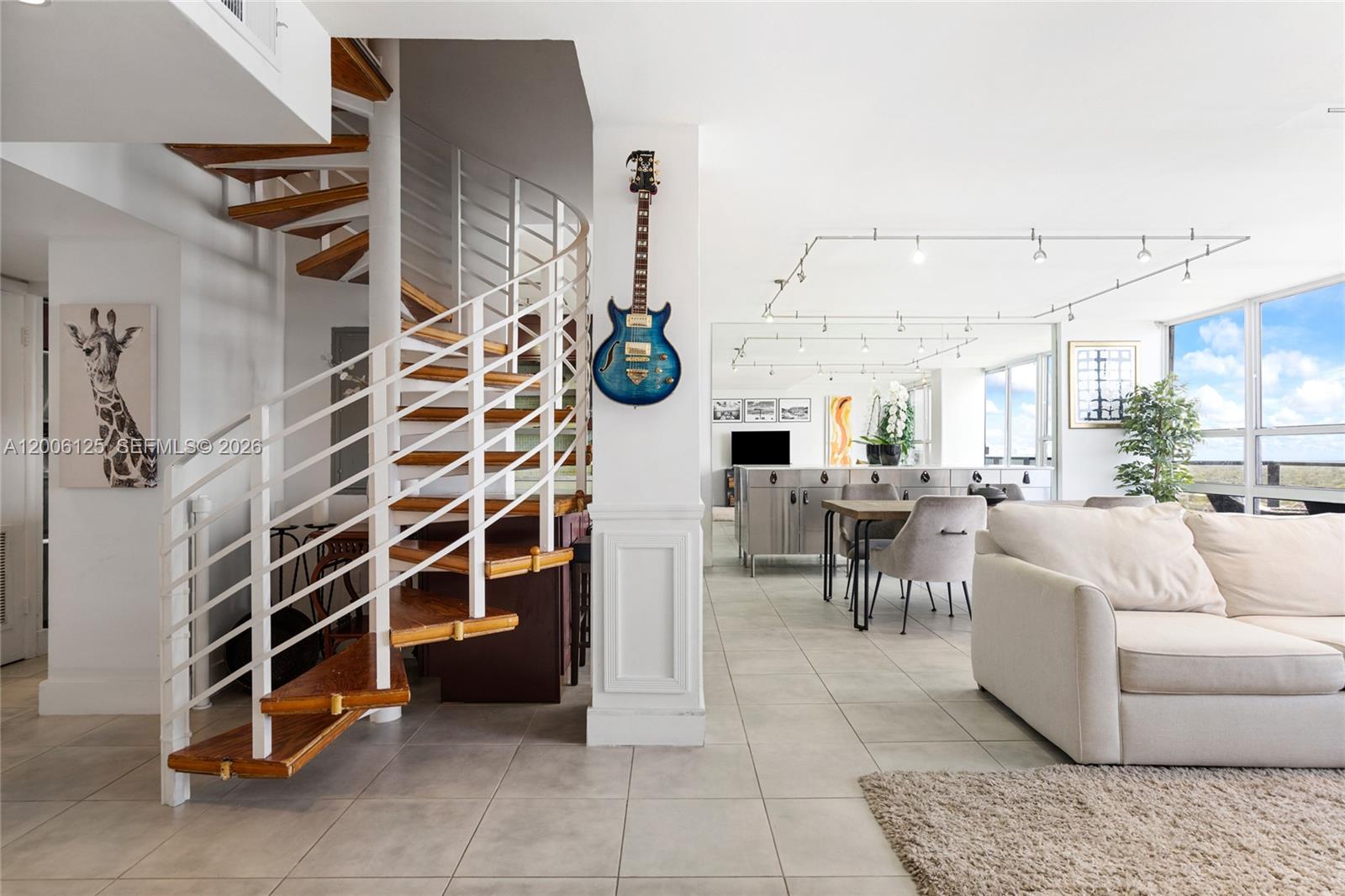 A living room features a spiral staircase, a wall-mounted guitar, and a dining area — 600 NE 36th St, Miami FL 33137, MIAMI, FL
