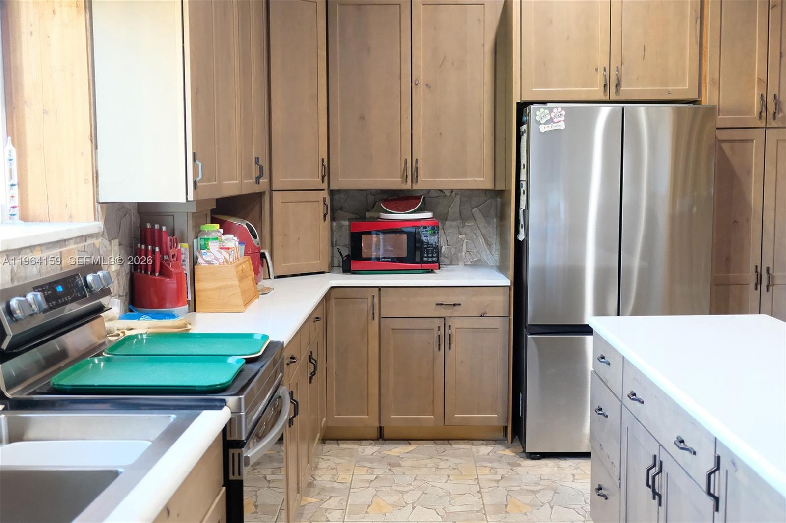 A kitchen features wood cabinets, stainless steel appliances, white countertops, and a stone backsplash — 5271 US HWY 441 SE, Okeechobee FL 34974, OKEECHOBEE, FL