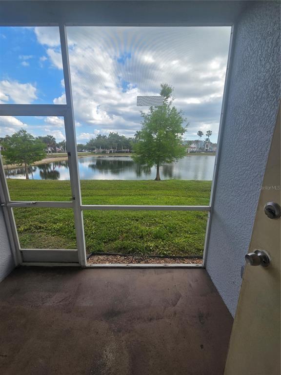 A view of a pond and trees from a screened-in porch with a concrete floor — 8312 BERNWOOD COVE LOOP UNIT 1007, FORT MYERS, FL