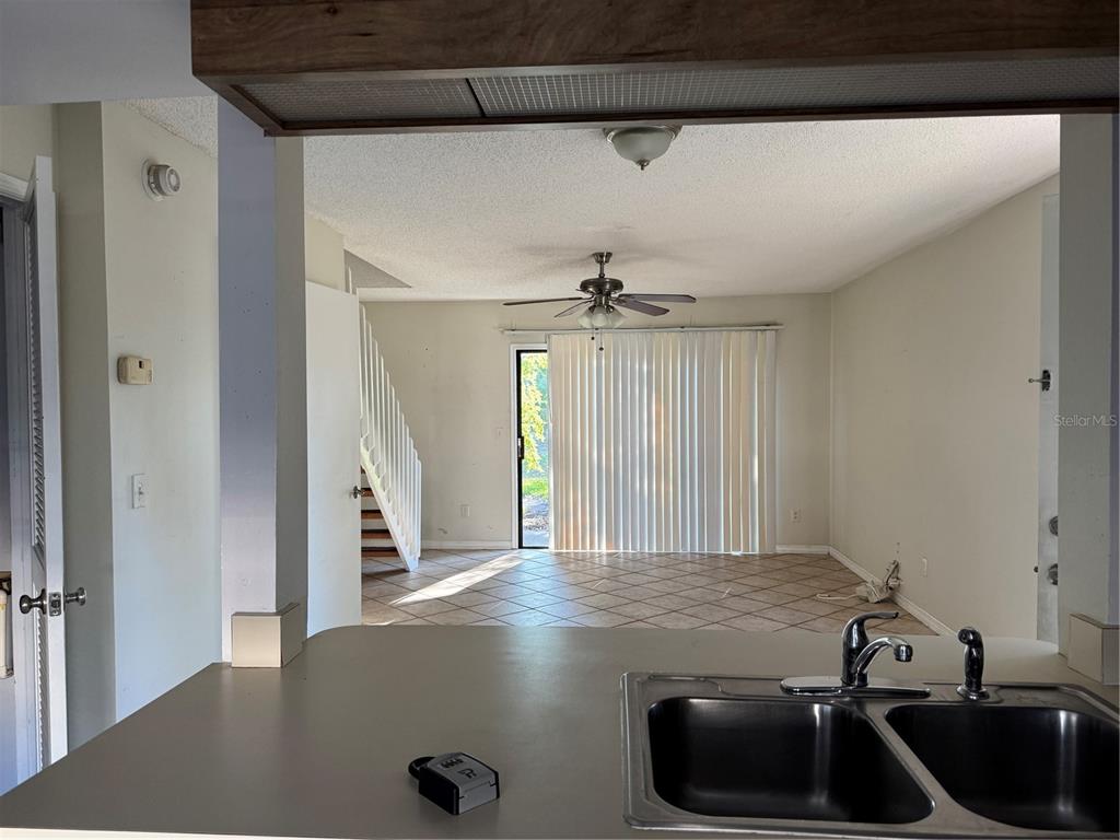 A view from a kitchen sink looking toward a living area with tile floors — 16573 BRIGADOON DRIVE, TAMPA, FL