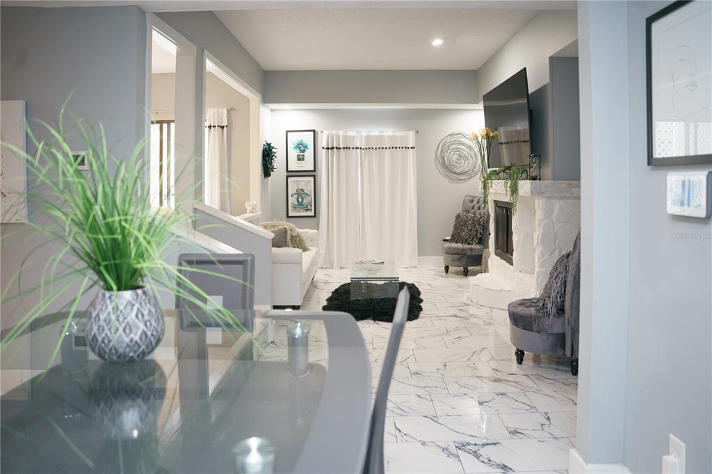 A living room features white tile floors, a stone fireplace, and a glass dining table — 4405 W FAIR OAKS AVENUE UNIT 2, TAMPA, FL
