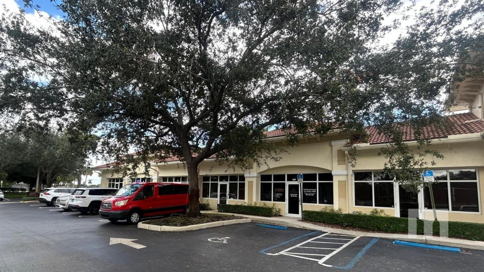 A red van is parked in front of a commercial building with a large tree — 9710 Stirling Road # 111A, Cooper City FL 33024, COOPER CITY, FL