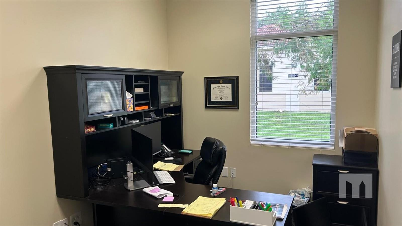 A home office features a dark wood desk, a hutch, and a window with blinds — 9710 Stirling Road # 111A, Cooper City FL 33024, COOPER CITY, FL