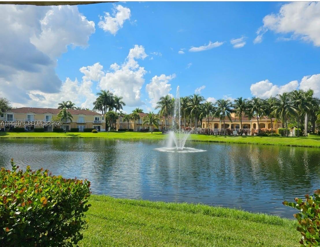 A fountain sits in the center of a lake surrounded by palm trees and buildings — 3076 SW 129th Ave # 152, Miramar FL 33027, MIRAMAR, FL