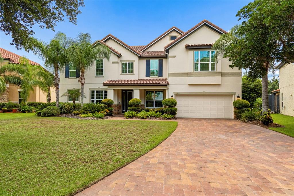 A two-story suburban house with a beige stucco exterior, tile roof, and paved driveway — 1804 BELLA CASA COURT, TAMPA, FL