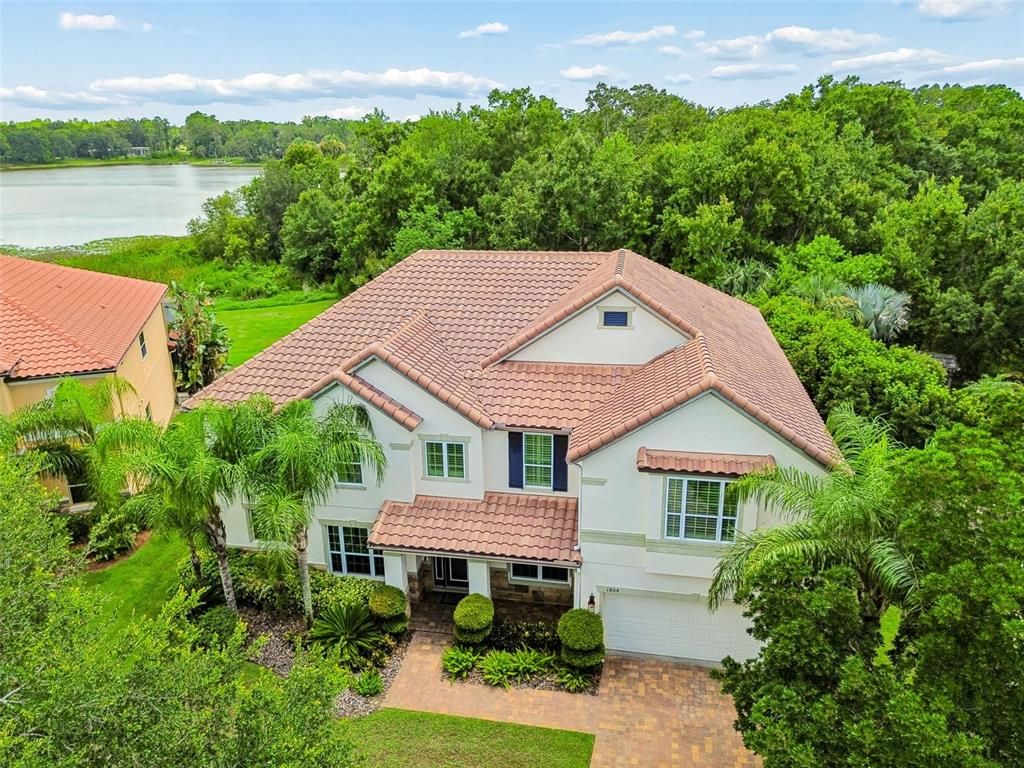 An aerial view of a two-story house with a tiled roof, garage, and landscaped yard — 1804 BELLA CASA COURT, TAMPA, FL