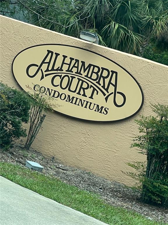 An oval sign for Alhambra Court Condominiums is mounted on a beige stucco wall — 5213 VIA HACIENDA CIRCLE UNIT 306, ORLANDO, FL