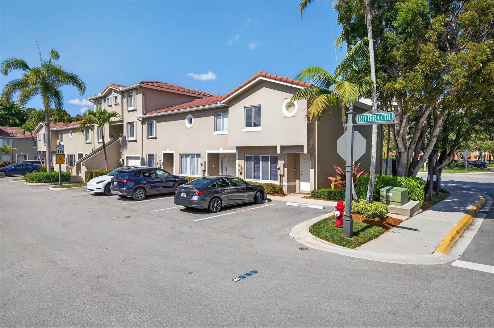 A multi-story tan townhouse building with a parking lot and palm trees in front — 245 Riviera Circle # 245, Weston FL 33326, WESTON, FL
