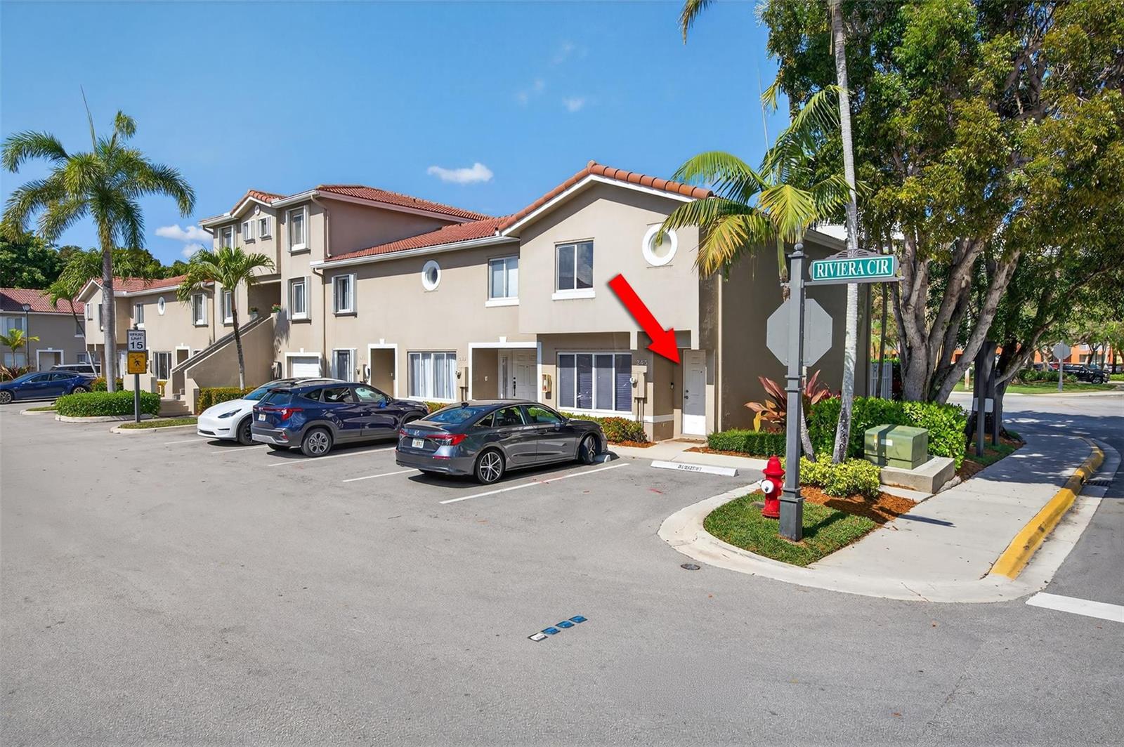 A multi-story townhouse exterior with a red arrow pointing to the front entrance door — 245 Riviera Circle # 245, Weston FL 33326, WESTON, FL