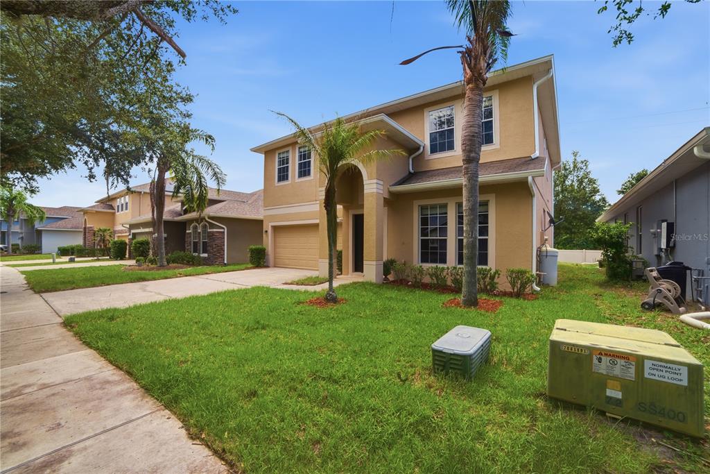 A two-story tan stucco house with a garage and a front lawn — 5341 PEPPER BRUSH COVE, APOPKA, FL