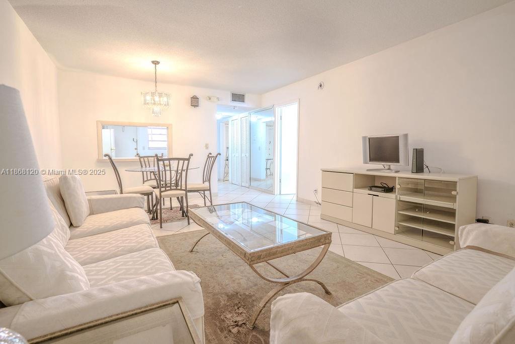 A living room features white sofas, a glass coffee table, and a dining area — 215 SE 3rd Ave # 401D, Hallandale Beach FL 33009, HALLANDALE BEACH, FL