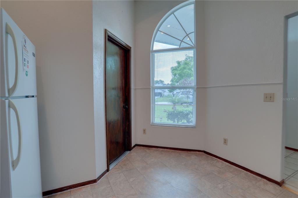 A kitchen nook features tile flooring, a large arched window, and a dark wood door — 10038 LITTLE TEAK STREET, ORLANDO, FL