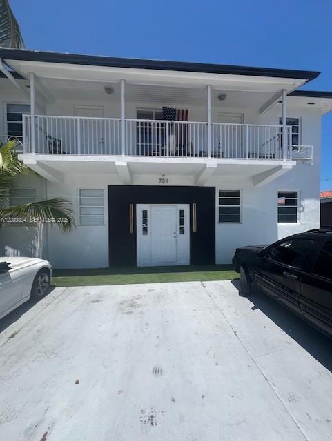 A two-story white building features a second-floor balcony and a central ground-level entrance — 701 82nd St # 1, Miami Beach FL 33141, MIAMI BEACH, FL