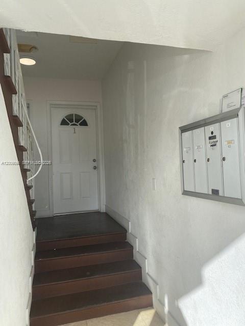 An indoor entryway features a wooden staircase leading to a white door labeled number one — 701 82nd St # 1, Miami Beach FL 33141, MIAMI BEACH, FL