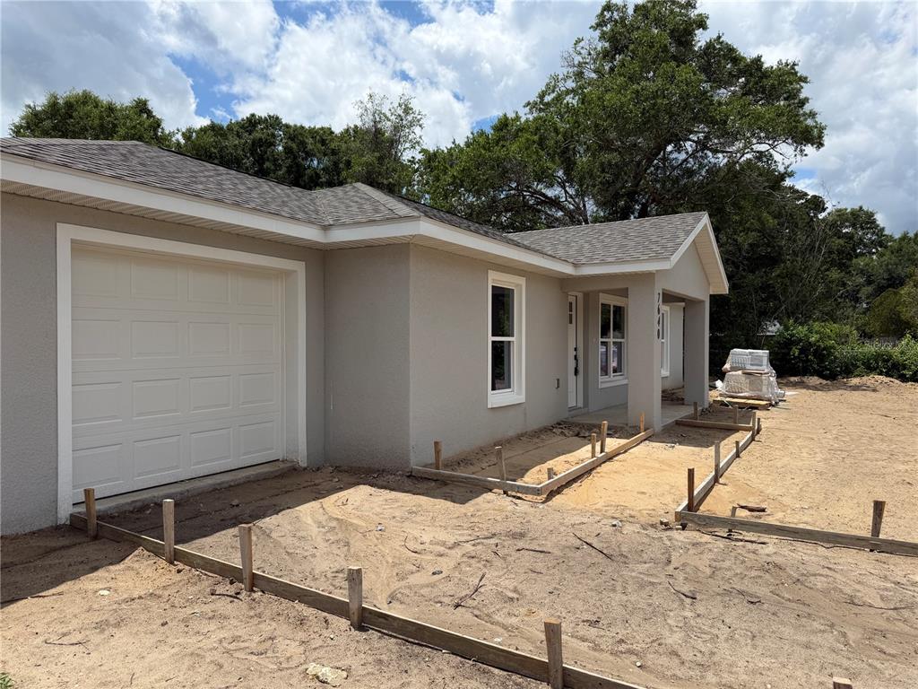 A single-story house exterior with a garage and wooden forms for a concrete driveway — 7640 SW 14TH STREET, OCALA, FL