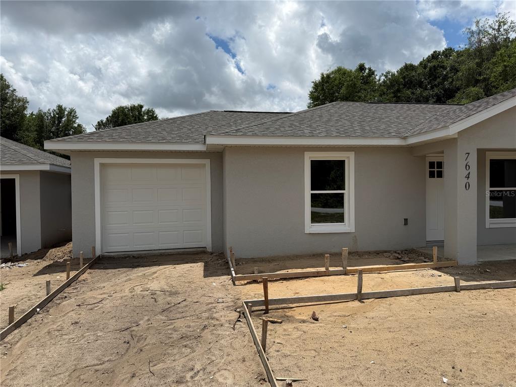A single-story house with a garage and unfinished concrete driveway forms under construction — 7640 SW 14TH STREET, OCALA, FL
