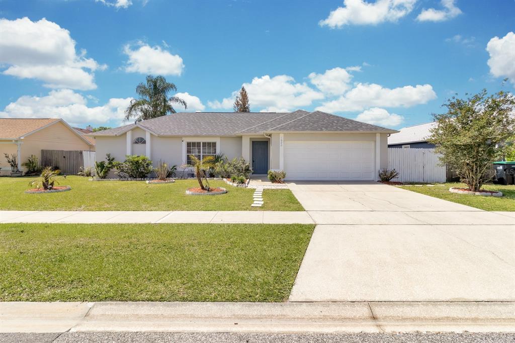 A single-story house with a gray roof, beige siding, and a two-car garage — 1620 GOLDEN POPPY COURT, ORLANDO, FL