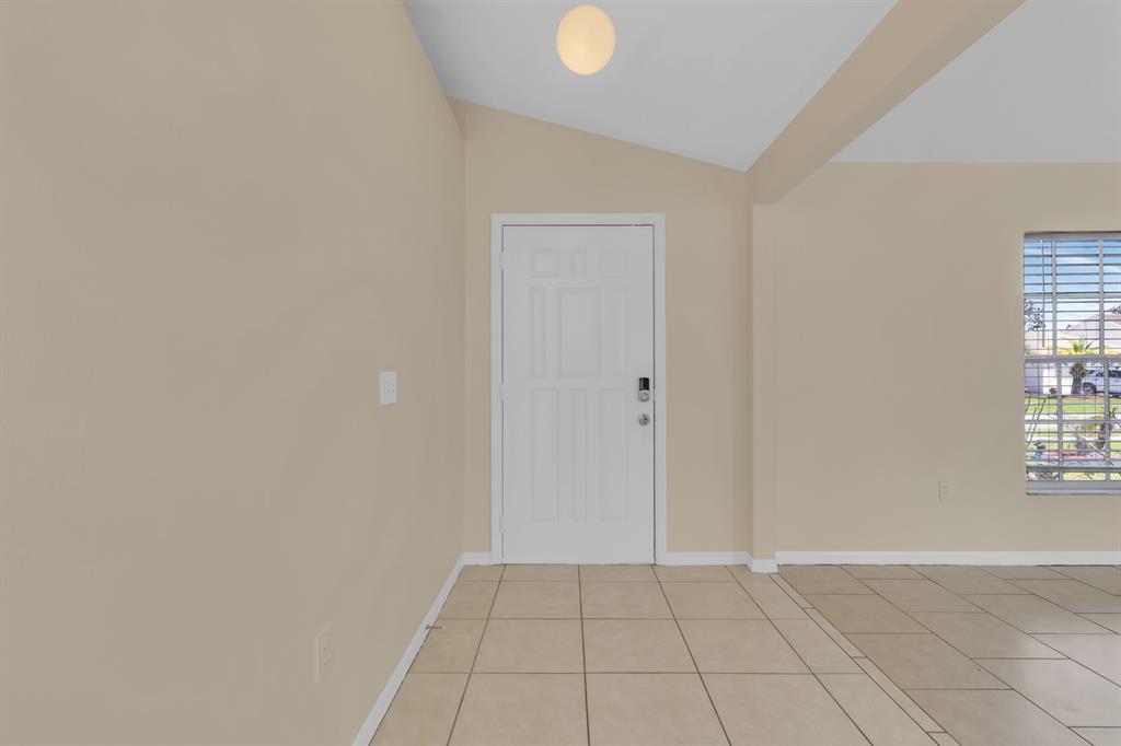 An entryway with beige walls, tiled floors, a white front door, and a window — 1620 GOLDEN POPPY COURT, ORLANDO, FL