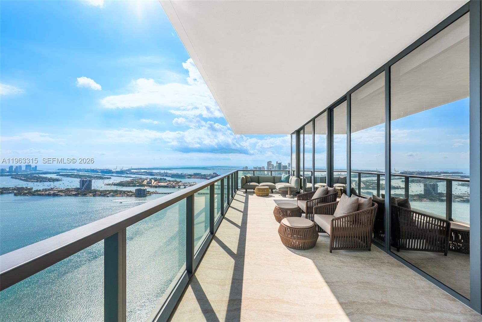 A high-rise balcony features outdoor seating, glass railings, and expansive views of the bay — 788 NE 23rd St # 5501, Miami FL 33137, MIAMI, FL
