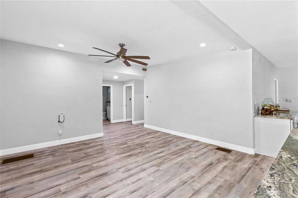 A living room with light gray walls, wood-look flooring, a ceiling fan, and recessed lighting — 1502 MONTCALM STREET, ORLANDO, FL