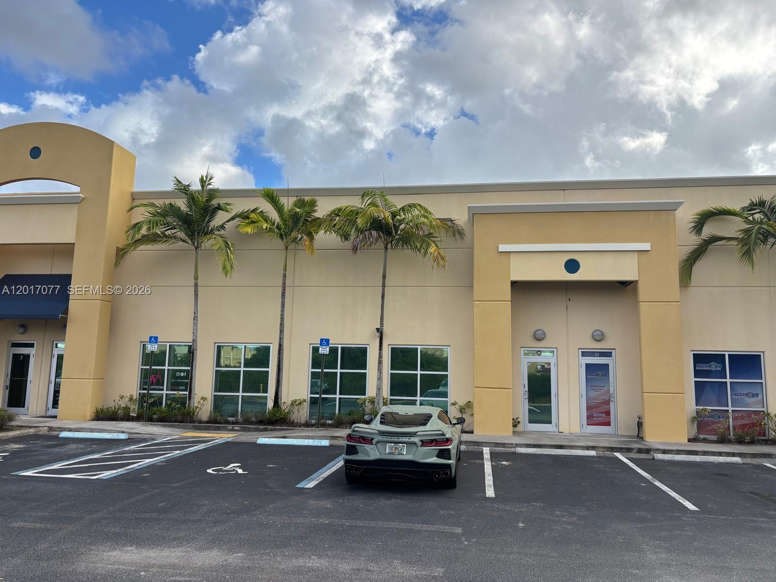 A light-colored commercial building exterior features palm trees and a parked sports car — 10380 W State Road 84, Davie FL 33324, DAVIE, FL