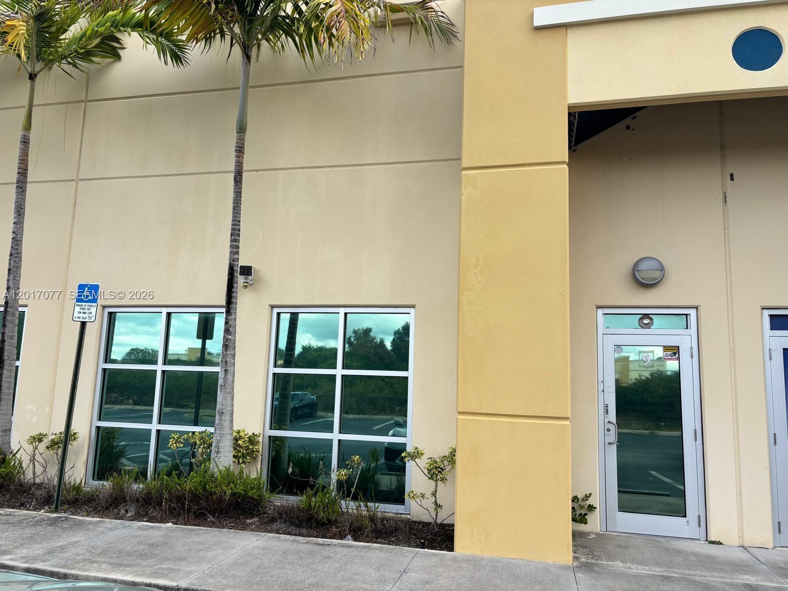 The exterior of a commercial building features a glass door, windows, and palm trees — 10380 W State Road 84, Davie FL 33324, DAVIE, FL