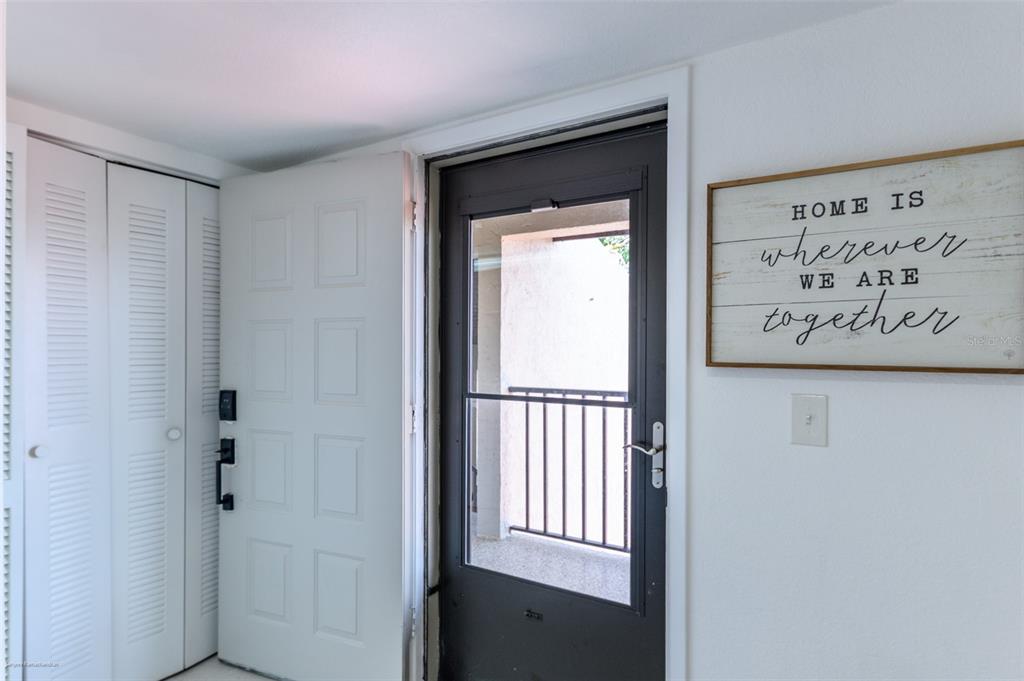 An interior entryway features a white door, a dark storm door, and a wall sign — 2601 W MARION AVENUE UNIT 41C, PUNTA GORDA, FL