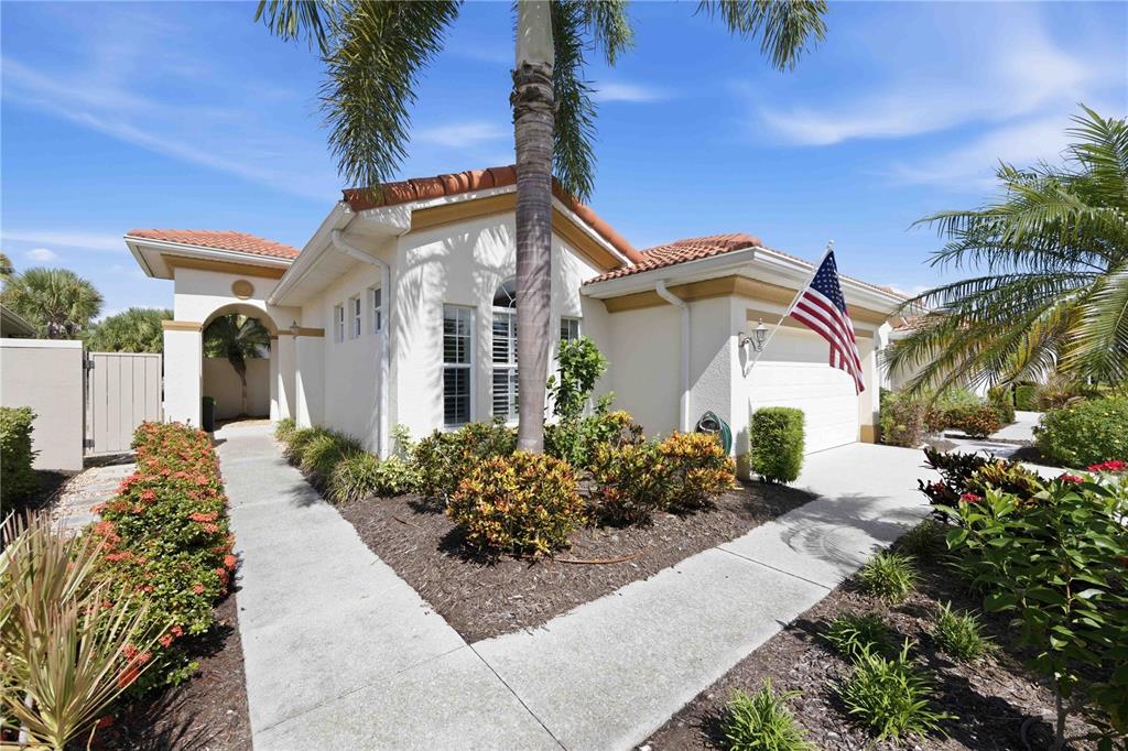 A single-story house with a white stucco exterior, tile roof, and a front walkway — 225 MESTRE PLACE, NORTH VENICE, FL