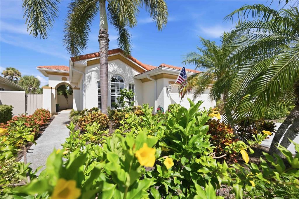 A single-story house with a tile roof, palm trees, and a walkway leading to the entrance — 225 MESTRE PLACE, NORTH VENICE, FL