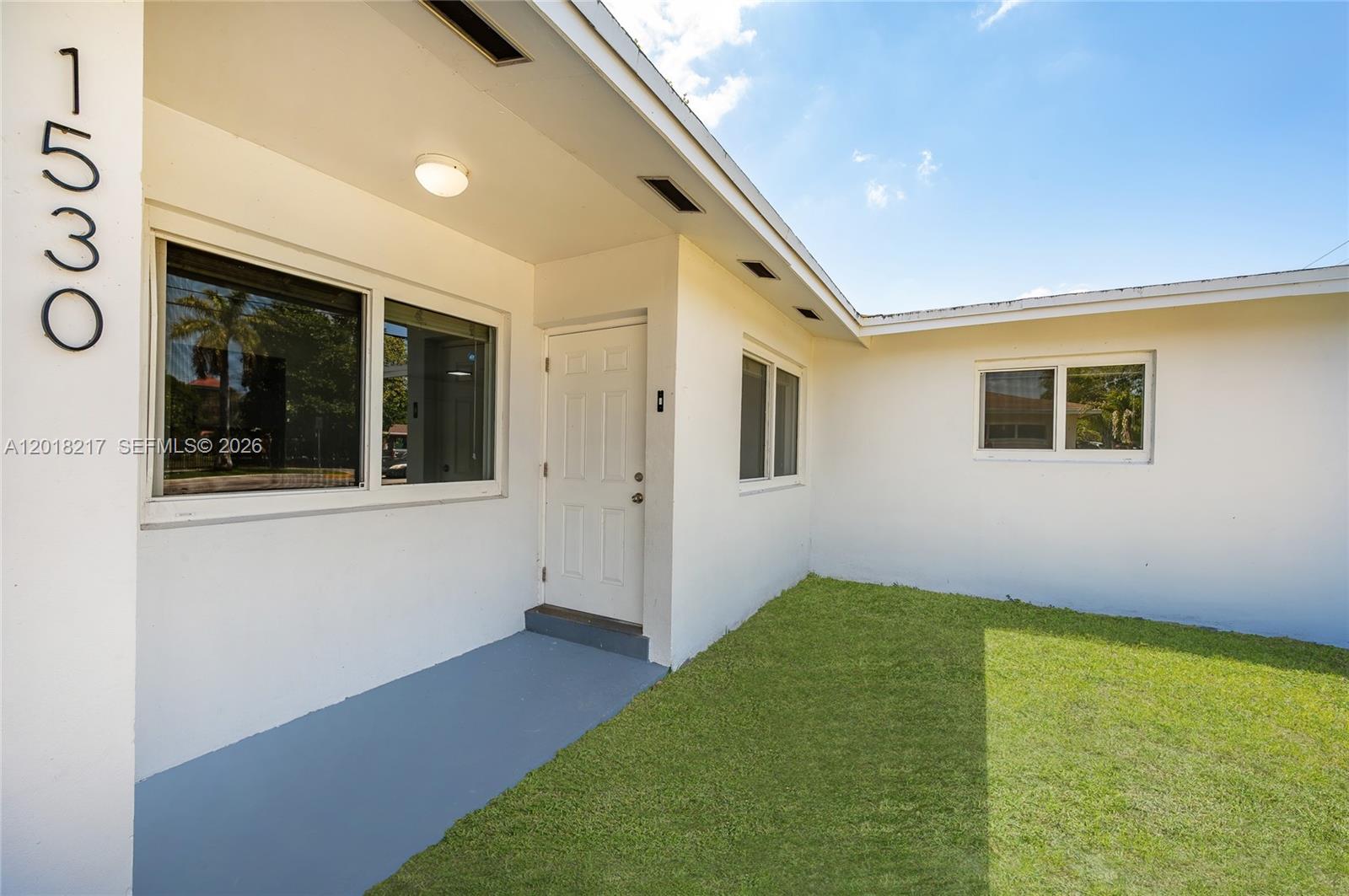 The exterior of a white house features a front door, windows, and a small lawn — 1530 NW 47th Ave, Lauderhill FL 33313, LAUDERHILL, FL