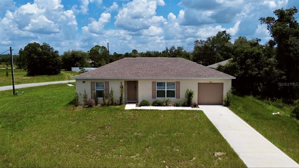 A single-story house with a tan exterior, a brown roof, and an attached garage — 360 BASS COURT, KISSIMMEE, FL