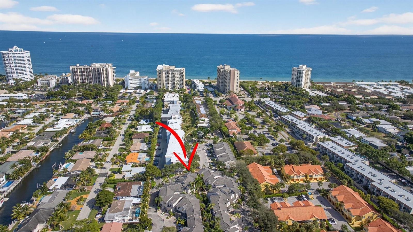 An aerial view shows a residential neighborhood with multi-story buildings and a nearby coastline — 1900 Oceanwalk Lane # 138, Pompano Beach FL 33062, POMPANO BEACH, FL