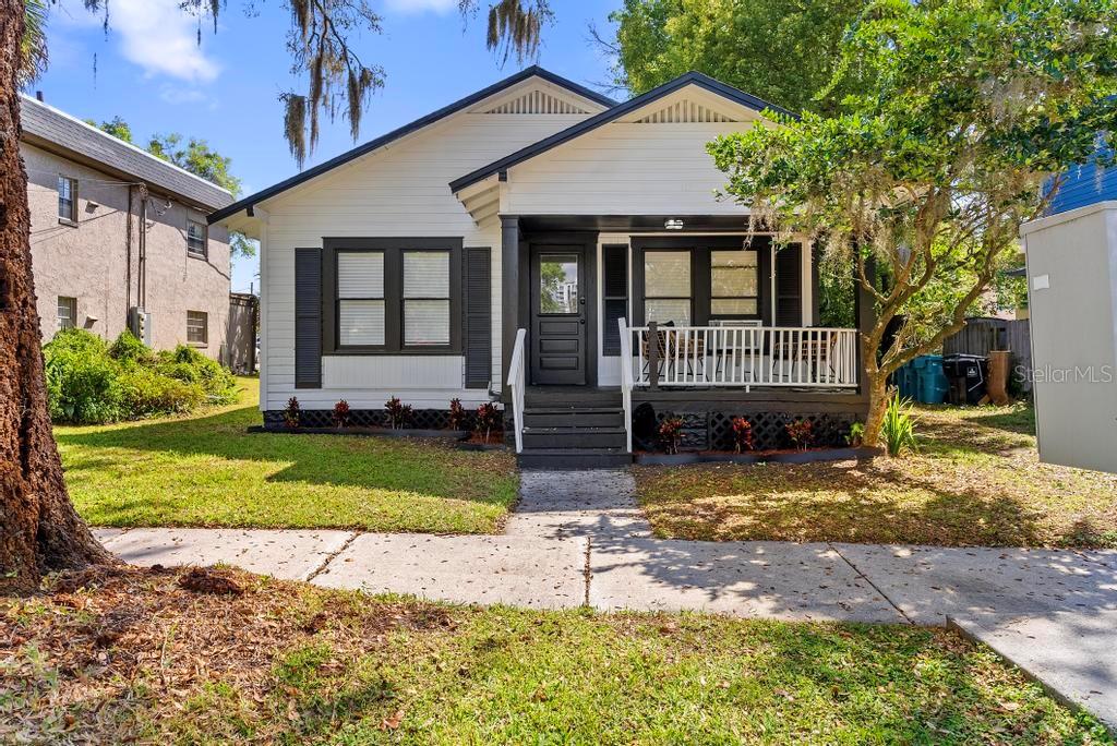 A white bungalow house features a front porch, dark trim, and a small front yard — 412 E HARWOOD STREET UNIT 4, ORLANDO, FL