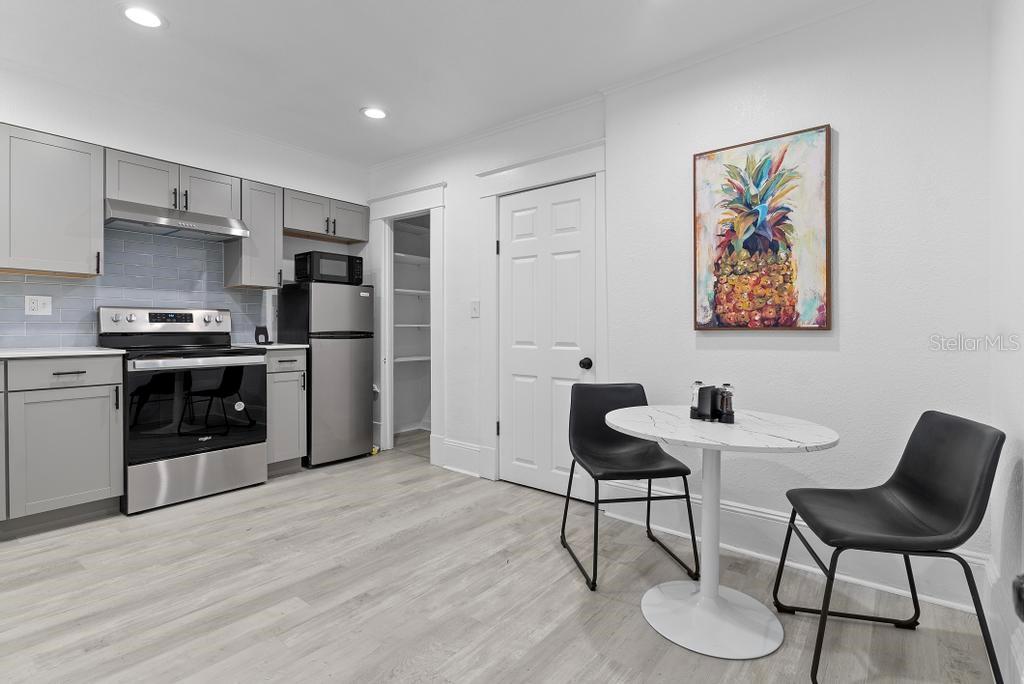 A kitchen with gray cabinets, stainless steel appliances, and a small dining table with chairs — 412 E HARWOOD STREET UNIT 4, ORLANDO, FL
