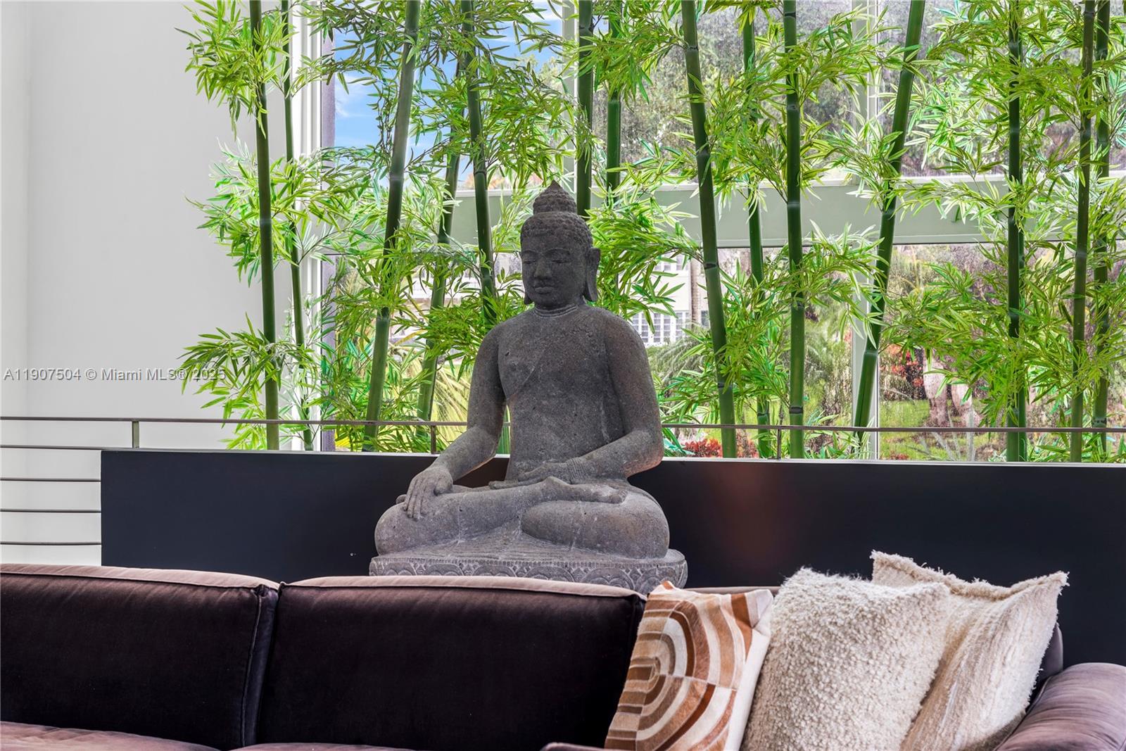 A stone Buddha statue sits on a ledge in front of indoor bamboo plants — 1606 S Bayshore Dr, Miami FL 33133, MIAMI, FL