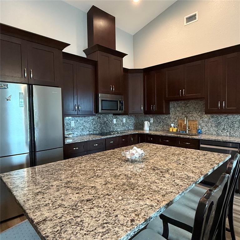 A kitchen features dark wood cabinets, granite countertops, a large island, and stainless steel appliances — 12201 ROSARO AVENUE, NORTH PORT, FL